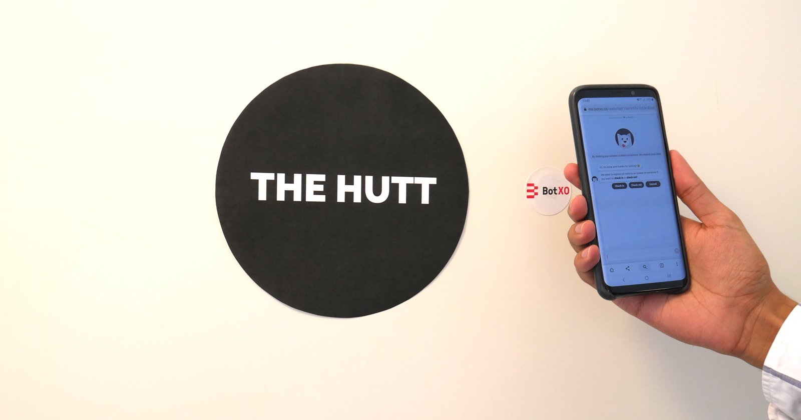 smartphone-nfc-tag-chatbot Person scanning an NFC tag on a door using a smartphone.